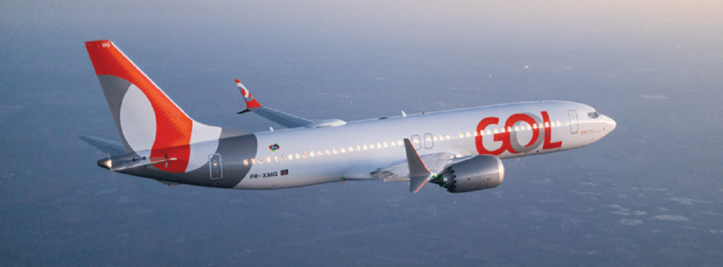Avião branco com detalhes em vermelho e cinza como o logo da companhia aérea