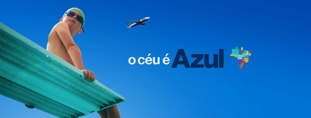 Um menino com roupas de mergulho com avião da azul sobrevoando ao fundo da imagem