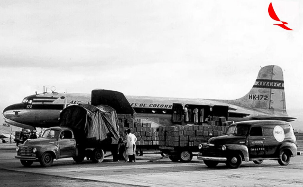 Carros, mercadorias e um avião antigo sendo mostrados em uma imagem preta e branca